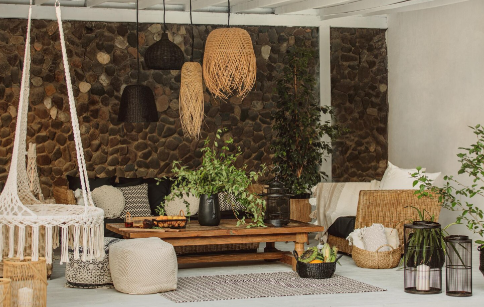 Stylish porch makeover with hanging chair, woven lighting, greenery, and cozy seating area on a budget.