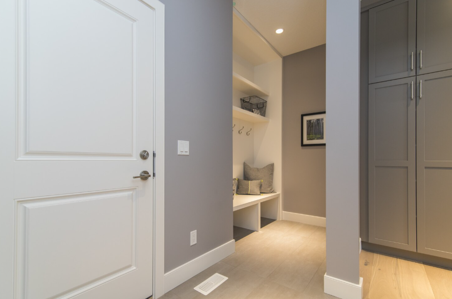 Light gray paint color brightening a modern hallway with white trim and built-in storage
